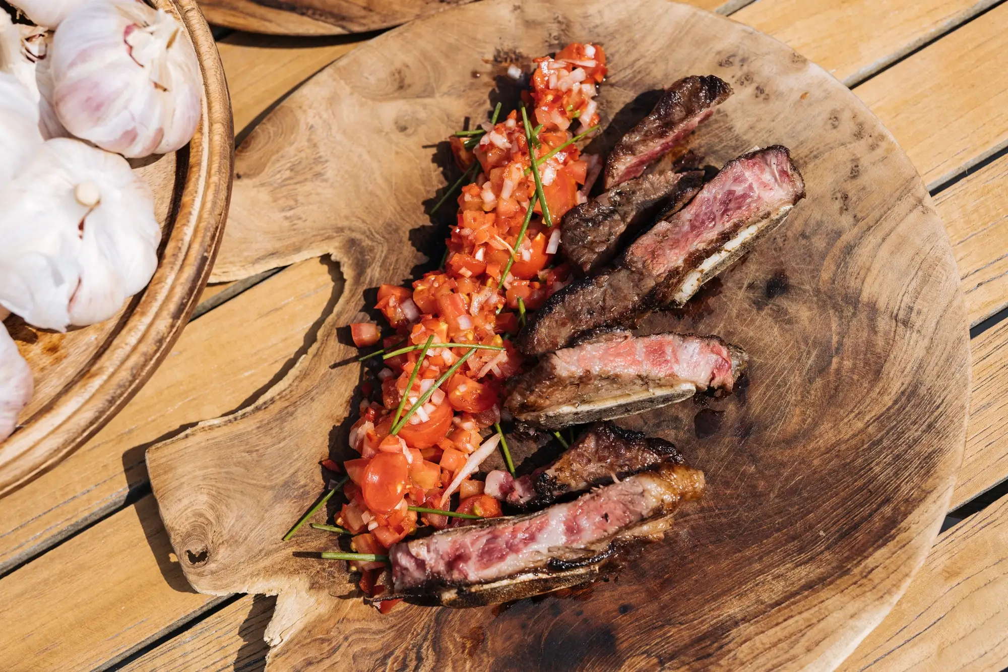Gegrilde bavette in plakken op een houten plank, met tomatensalsa